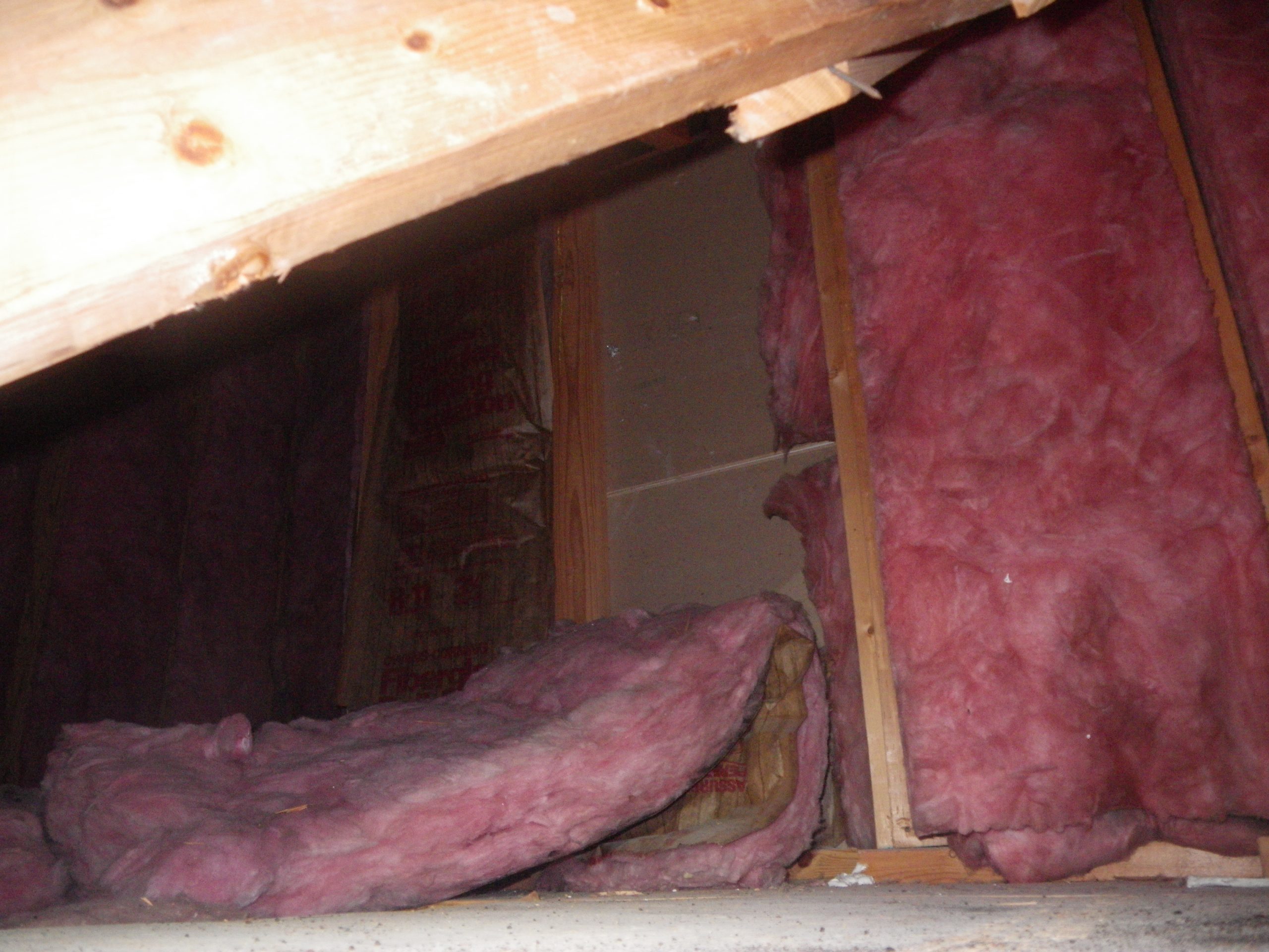 Attic insulation unsupported and falling from wall